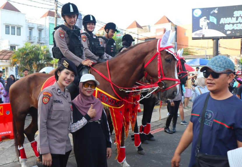 Seorang warga berfoto bersama pasukan polisi berkuda di area CFD Depok, Ahad (11/05/2025). (Foto: Dok RUZKA INDONESIA)