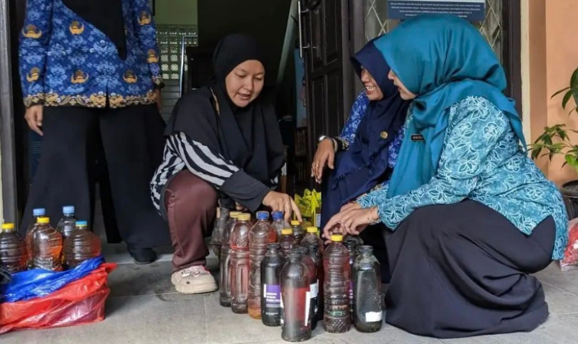 Salah seorang warga Kota Depok saat menukarkan minyak jelantah ke posko penukaran minyak jelantah di Sekretariat PKK Kota Depok di Balai Kota Depok. (Foto: Dok Diskominfo Kota Depok)