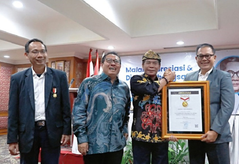 Gubernur Zainal Paliwang menerima penghargaan dari SMSI. (Diskominfo)