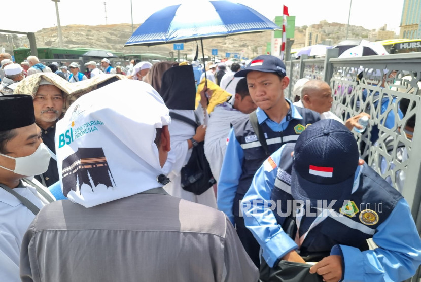 Petugas membantu jamaah haji Indonesia yang pulang ke hotel usai shalat Jumat.