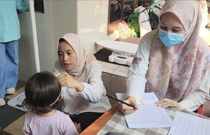 Pengukuran berat badan dan lingkar kepala anak yang dilakukan oleh FKUI di Posyandu RW 15, Kelurahan Kayu Putih, Jakarta Pusat. Gambar: Republika 
