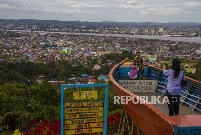 Warga berfoto dengan latar belakang Kota Samarinda.