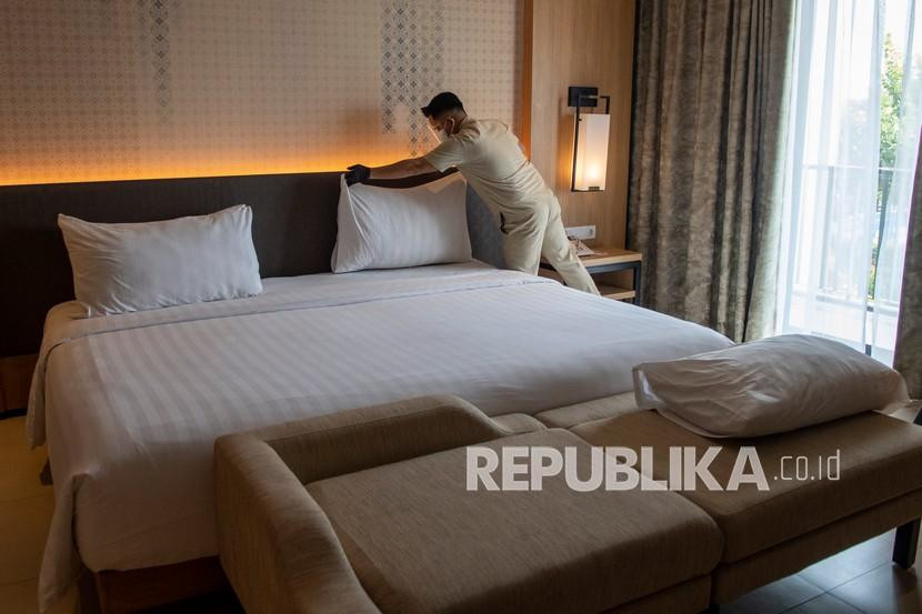 Karyawan membersihkan salah satu kamar di hotel.