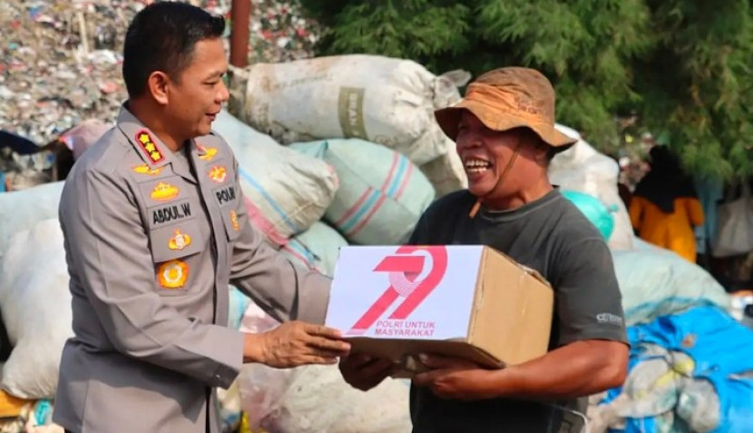 Kapolretro Depok, Kombes Abdul Waras menyerahkan bantuan ke warga TPA Cipayung. (Foto: Dok Diskominfo Kota Depok)