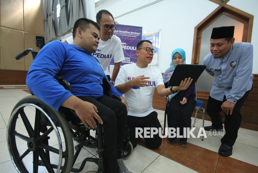 Group Head Region Central XLSMART Arif Farhan Budiyanto (dua kiri), Head of Corporate Communication & CSR XLSMART Indonesia Dani Miftahul Akhyar (tengah), dan Operation Director LAZ Darut Tauhid Peduli Jajang Nurjaman (kanan), bersama dua disabilitas daksa saat pelatihan XLSMART Peduli Disabilitas Berdaya 2025, di Daarul Hajj, Geger Kalong, Kota Bandungi, Kota Bandung, Selasa (17/6). Foto: Edi Yusuf