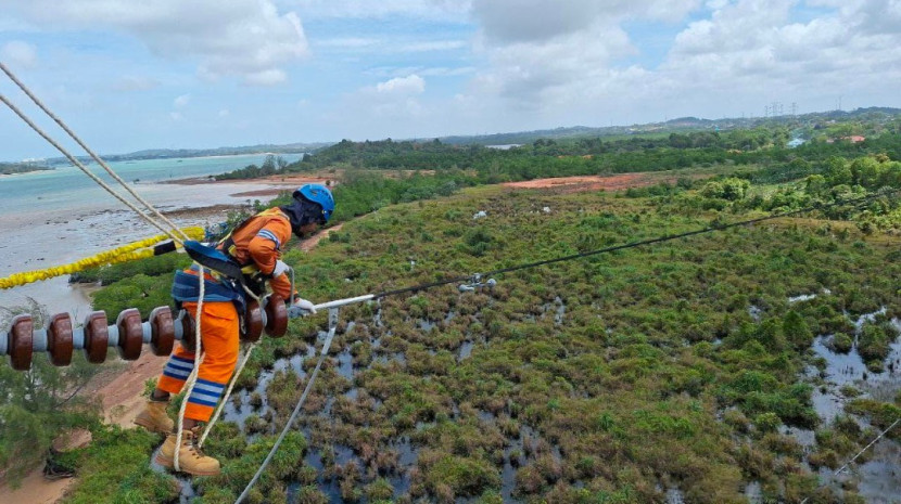 Petugas PLN tengah melakukan pemeliharaan jaringan transmisi Saluran Udara Tegangan Tinggi (SUTT) 150 kiloVolt (kV) sebagai bagian dari upaya memastikan keandalan pasokan listrik secara nasional. Komitmen ini menjadi fondasi dalam mendorong peningkatan kinerja PLN, yang pada Tahun Buku 2024 ini mencetak pendapatan sebesar Rp 545,38 triliun. (Foto: Dok PLN)