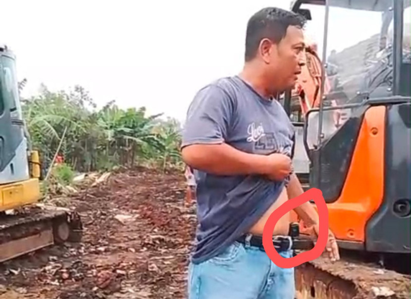 Seorang oknum pria mengaku orang pemerintah yang juga ring satu istana sambil menunjukan sebuah pistol di pingangnya. (Foto: screenshoot video)