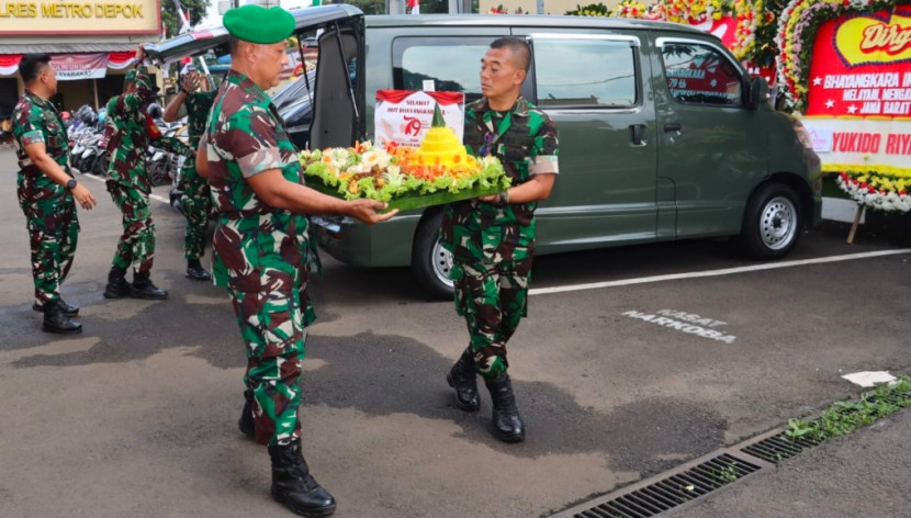 Pasukan TNI dari Kodim Depok memberikan tumpeng Hari Bhayangkara ke-79 ke Mapolres Metro Depok. (Foto: Dok RUZKA INDONESIA) 