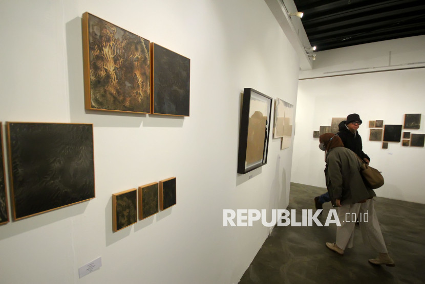 Pengunjung melihat karya seni rupa bertajuk 'Purnama (dan) Tilem' karya Iswanto Soerjanto yang dipamerkan di Orbital Dago Gallery, Kota Bandung. Foto: Edi Yusuf