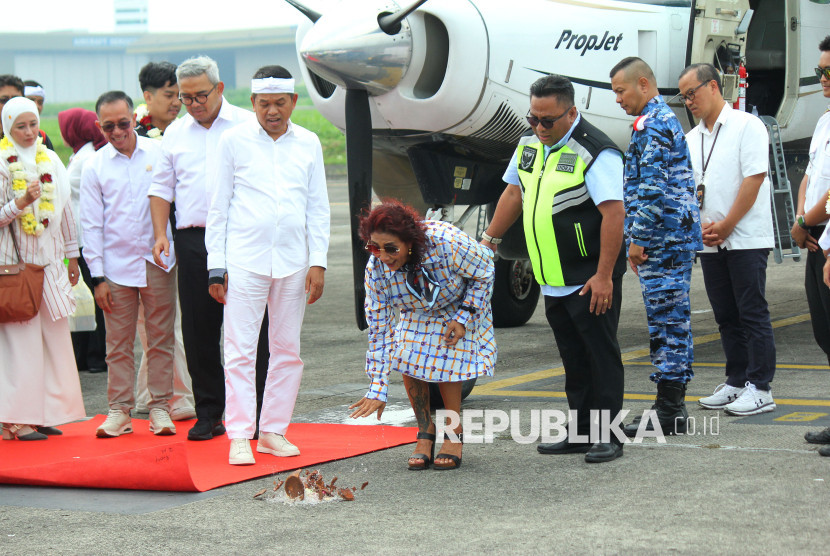 Pemecahan kendi oleh Pemilik pesawat Susi Air, Susi Pudjiastuti disaksikan Gubernur Jabar Dedi Mulyadi, Wali Kota Bandung Muhammad Farhan dan sejumlah pejabat terkait saat acara Inagurasi penerbangan perdana Susi Aiir di Bandara Husein Sastranegara, Kota Bandung, Rabu (2/7/2025). Foto: Edi Yusuf