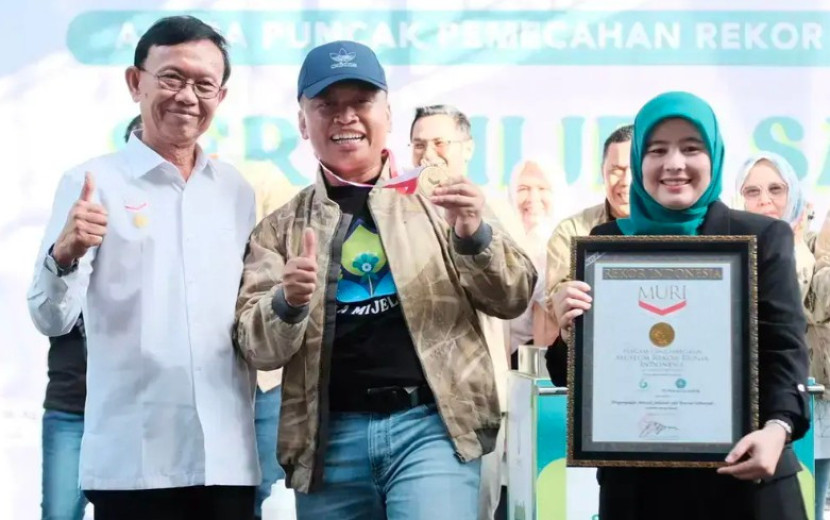 Wali Kota Depok, Supian Suri (tengah) bersama Ketua PKK Kota Depok, Siti Barkah Hasanah (kanan) menerima medali dan piagam Rekor MURI. (Foto: Dok Diskominfo Kota Depok)