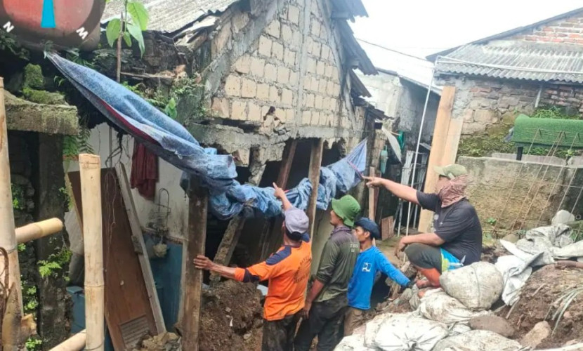 Satgas Dinas PUPR Kota Depok sedang membersihkan material longsor yang menutupi saluran air. (Foto: Dok Diskominfo Kota Depok)