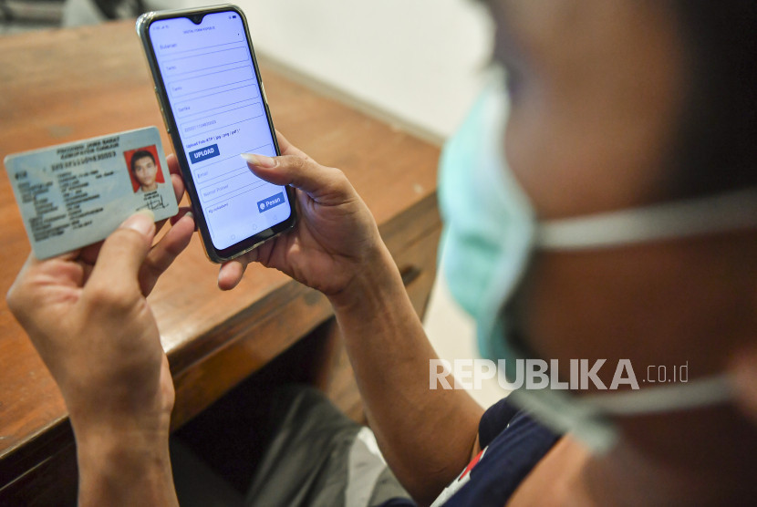 Seorang warga mengisi data pribadi di sebuah aplikasi.