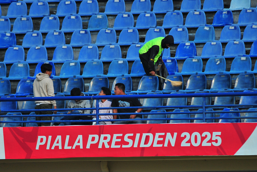 Petugas kebersihan menyisir sampah di tribun penonton di sela laga Piala Presiden 2025 di Stadion si Jalak Harupat, Kabupaten Bandung. KANGJEPRET/YOGIARDHI (Data teknis: Nikon D3, Nikkor 300/2.8 ED Manual Focus) 