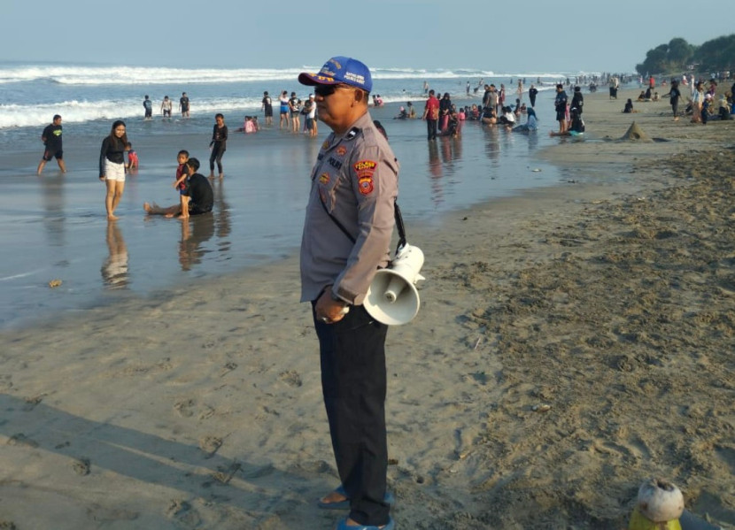 Anggota kepolisian Pol Airud Polres Garut, Aipda Sumar saat lakukan patroli di Pantai Karang Papak. (Foto: Dok Ridwan).