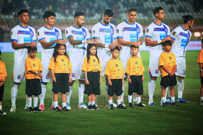 Tim Thai Port FC melindungi kepala anak-anak player escort karena hujan sebelum laga final turnamen pramusim Piala Presiden 2025 di Stadion Si Jalak Harupat, Kabupaten Bandung, Ahad (12/7/2025). KANGJEPRET/YOGIARDHI, (Data teknis: Nikon D700, Nikkor 80-200/2.8 ED 3rd GEN). 