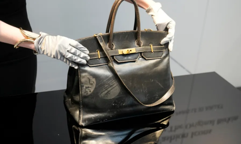 Petugas lelang memamerkan tas Birkin asli dibuat Hermès untuk Jane Birkin 1984. (AFP)