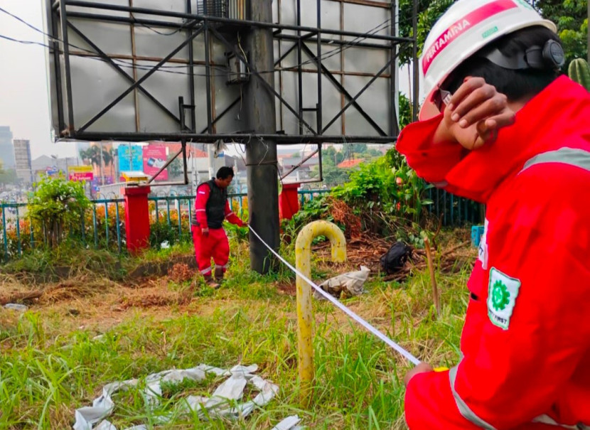 Petugas Pertagas sedang melakukan pengukuran ulang lahan miliknya di pertigaan lampu merah Jalan Juanda-Pertagas. Fakta terungkap, 2 bilboard berada di lahan milik aset Pemkot Depok. (Foto: Dok RUZKA INDONESIA) 