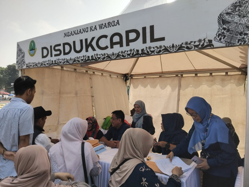Warga tengah mendapatkan layanan di gerai disdukcapil Kota Sukabumi di Lapang Merdeka, Jumat (25/7/2025).