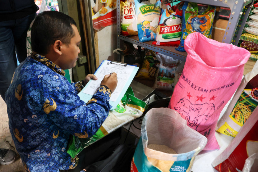 Petugas dari Dinkopdag Surabaya melakukan pengecekkan beras yang dijual di pasar Kota Surabaya. FOTO: Humas Pemkot Surabaya