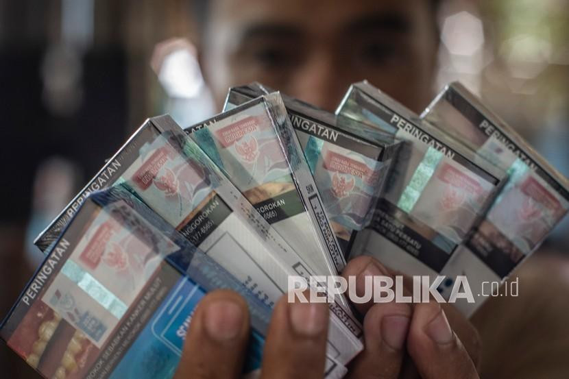 Pedagang menunjukkan bungkus rokok bercukai. Gambar: Republika