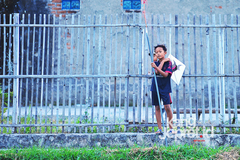Seorang anak pemburu layang-layang putus di tanah lapang Lingkung Cai Kel Kujangsari, Bandung Kidul, Kamis (31/7/2025). Kangjepret/Yogi Ardhi (Data Teknis Nikon D3, Nikkor AF Nikkor AF 80-200mm f/2.8 ED 3rd gen).
