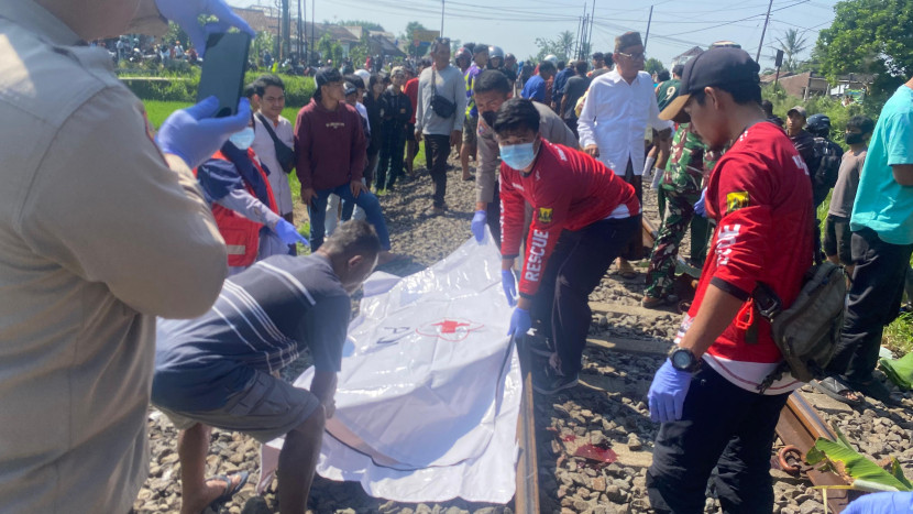 Petugas PMI Kabupaten Sukabumi mengevakuasi korban tertabrak kereta di Desa Cimahi, Kecamatan Cicantayan, Kabupaten Sukabumi, Sabtu (2/8/2025).