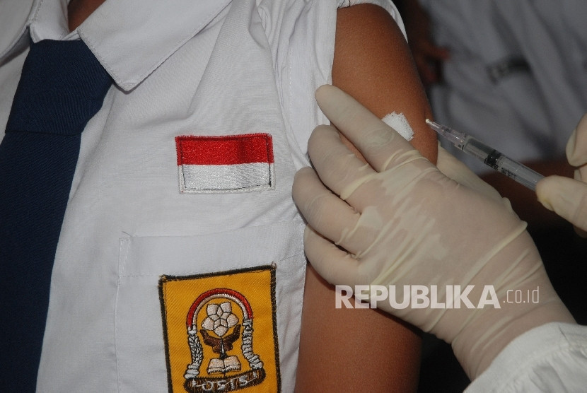 Petugas kesehatan memberikan vaksin Measles Rubella (MR) kepada siswa saat Kampanye Imunisasi Campak dan MR di SMPN 9, Bandung, Jawa Barat. Gambar: Republika
