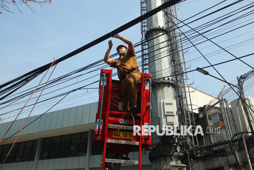 Wakil Wali Kota Bandung Erwin terjun langsung ikut merapikan kabel saat meninjau perapihan kabel telekomunikasi dan PLN di Jalan Laswi, Kota Bandung, Selasa (5/8/2025). Foto: Edi Yusuf