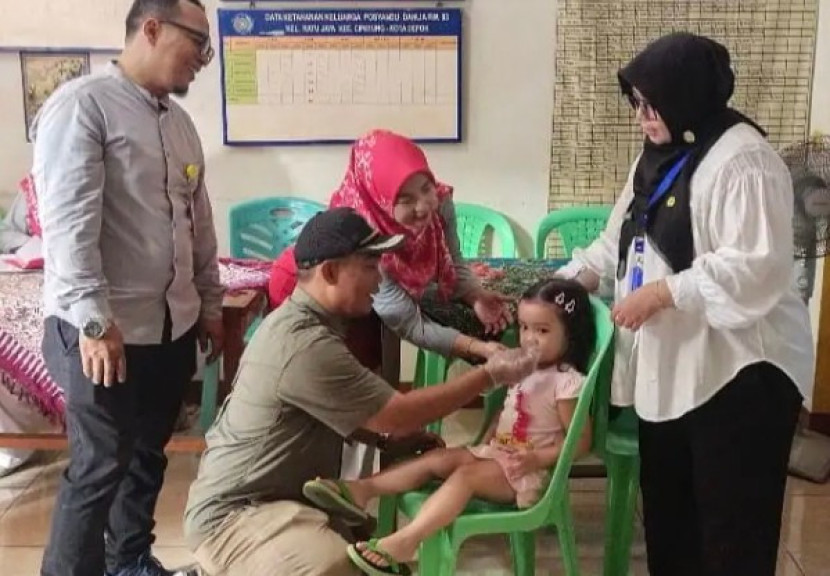 Lurah Ratujaya, Bambang Sugiharto memberikan vitamin A ke balita di Posyandu Dahlia RW 03, Kelurahan Ratujaya, Kecamatan Cipayung, Kota Depok, Selasa (05/08/2025). (Foto: Dok Kelurahan Ratujaya)