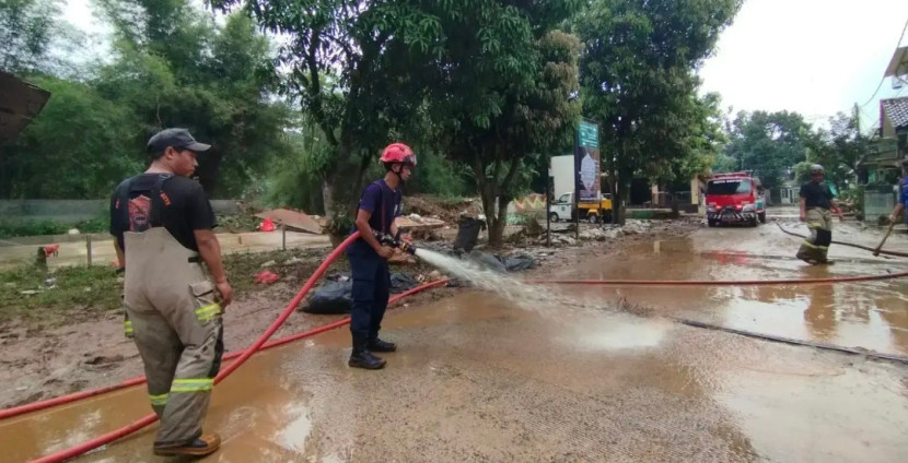 Petugas Damkar dan Dinas PUPR Kota Depok lakukan pembersihan lumpur akibat banjir di Pondok Petir, Bojongsari, Kota Depok. (Foto: Dok Diskominfo Kota Depok)