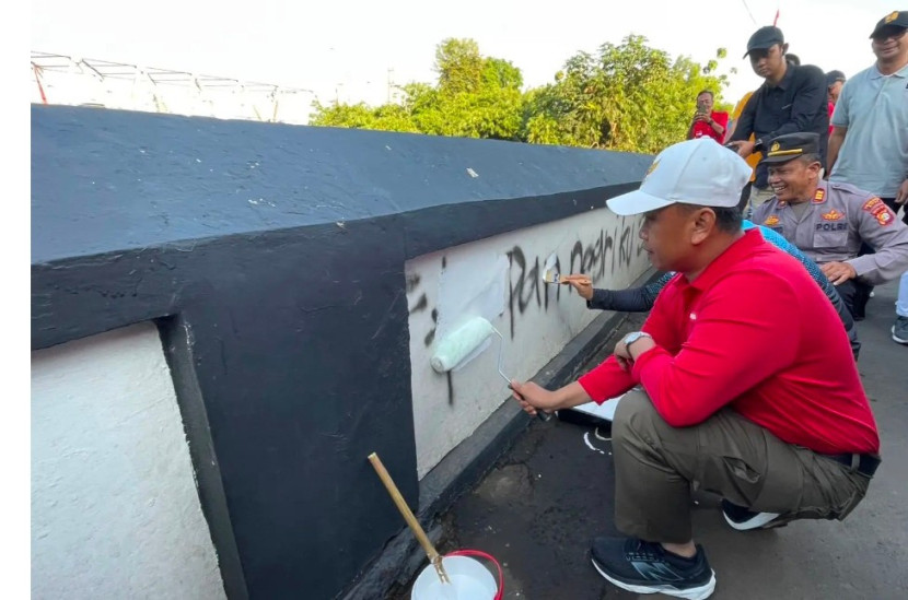 Wali Kota Depok, Supian Suri didampingi Kapolres Depok, Kombes Abdul Waras mengecat ulang dinding Jembatan Panus yang dipenuhi coretan vandalisme, Jumat (15/08/2025). (Foto: Dok Diskominfo Kota Depok) 