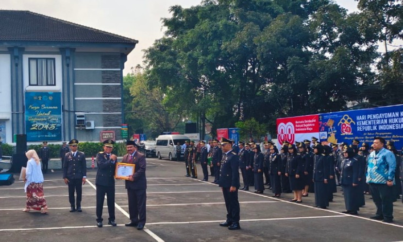 Ketua Kanwil Kemenkumhan Jabar menyerahkan piagam penghargaan kepada ketua DPRD Majalengka, H.Didi Supriadi, S.H., di Bandung. (Foto:Dok Eko Widiantoro)