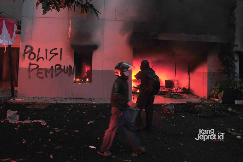 Pengunjuk rasa melintasi gedung heritage milik sekretariat MPR RI yang berada di depan Gedung DPRD Jawa Barat, Jumat (29/8/2025). Gedung heritage ini dibakar massa karena dianggap menjadi persembunyian aparat intelejen polisi.  (KANGJEPRET.ID/YOGI ARDHI) (Nikon D3, Nikkor 20mm/2.8 D).