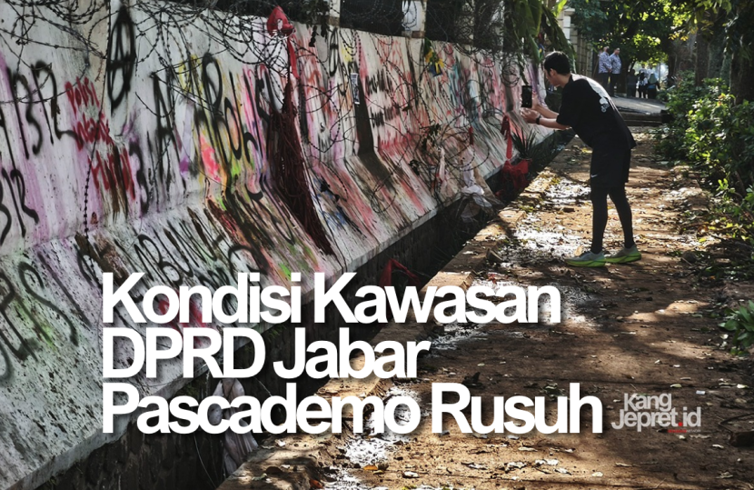 Seorang warga memotret coretan demonstran di pagar Gedung DPRD Jabar di Jalan Diponegoro Bandung, Sabtu (30/8/2025). Pascademo yang berakhir rusuh sebelumnya meninggalkan kerusakan di sana-sini di sekitar gedung wakil rakyat ini. (KANGJEPRET.ID/YOGI ARDHI) (Kamera: Xiaomi 14T).Â
