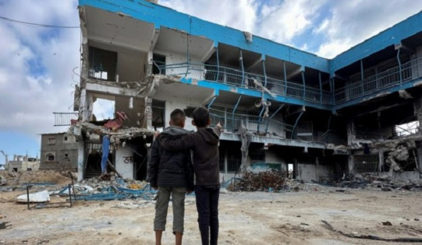 Dua anak Gaza menatap gedung sekolah yang dihancurkan penjajah zionis. (DoP)