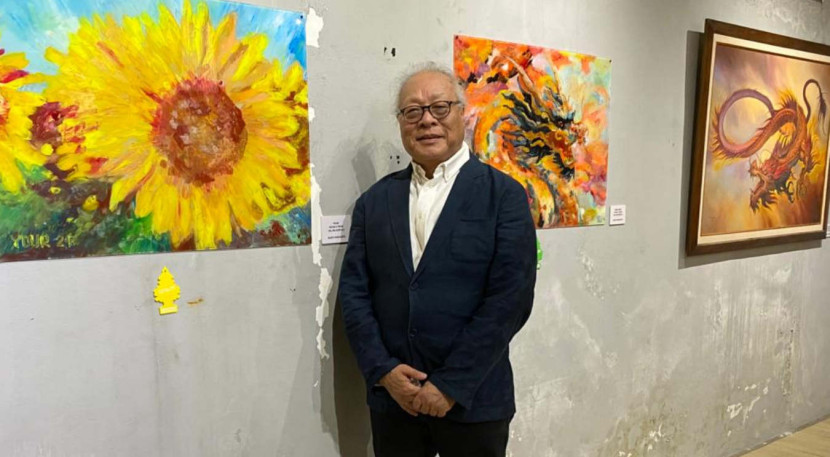 Rudy Harjanto, staf pengajar LSPR Institut Komunikasi dan Bisnis Jakarta, dengan tiga karyanya di Galeri Seni Lorong Senja, Bandung. (Foto: Dok RUZKA INDONESIA)