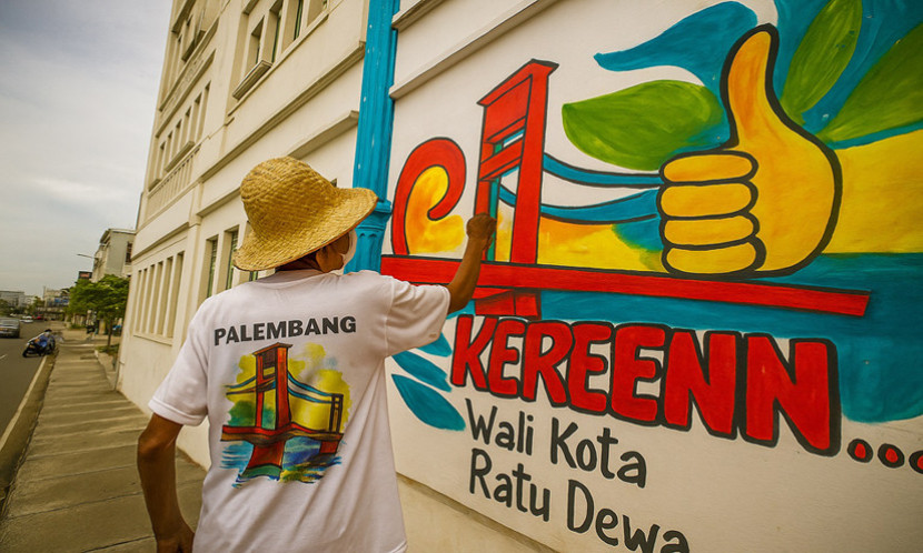Ilustrasi Seniman melukis Mural di sebuah gedung. (FOTO: AI)
