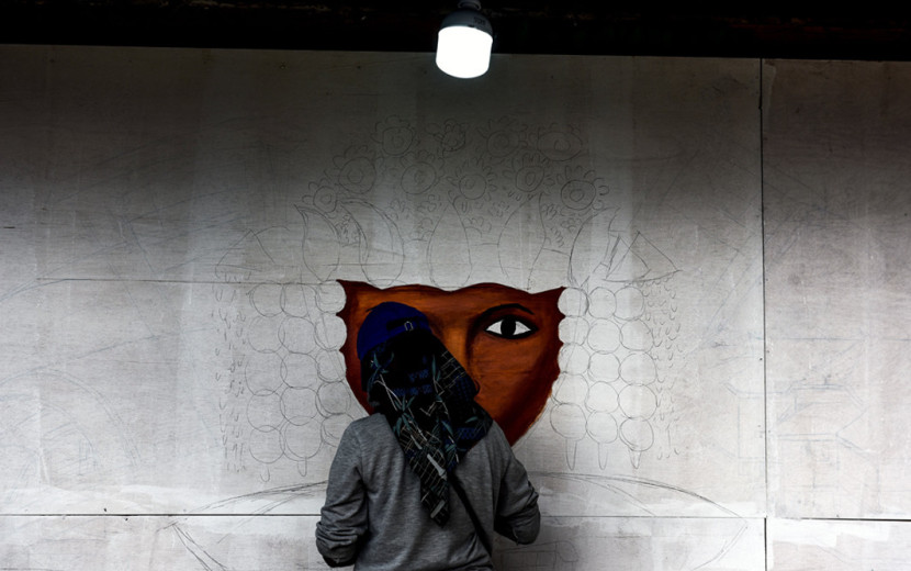 Pelukis Palembang tengah melukis mural. (FOTO: Ist/Msh)