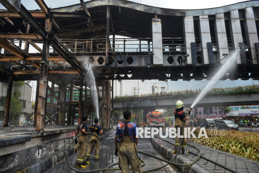 Petugas pemadam kebakaran menyemprotkan air ke halte Transjakarta Senen untuk membersihkan sampah dan juga sisa pembakaran yang dilakukan oleh perusuh di Kawasan Senen, Jakarta, Ahad (31/8/2025). (FOTO: Republika/ Prayogi)