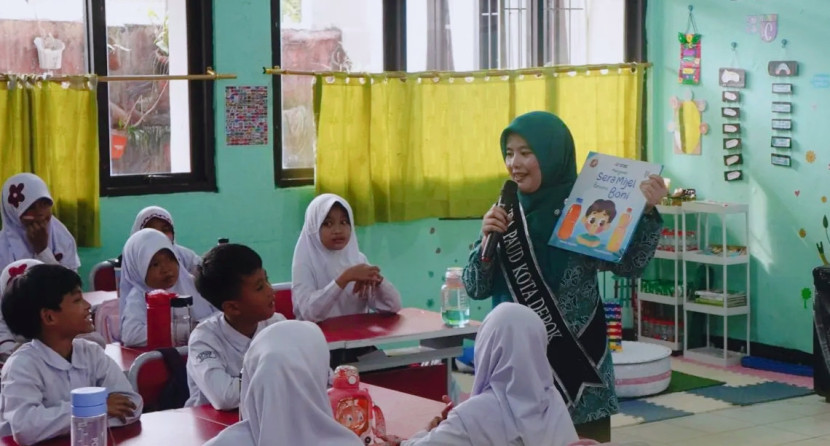 Ketua TP-PKK Kota Depok, Siti Barkah Hasanah, membacakan dongeng kepada siswa SDN Sukatani 4, Tapos, seusai meluncurkan Gerakan 7 Kebiasaan Anak Indonesia Hebat (G7KAIH), Kamis (11/09/25). Foto: Diskominfo