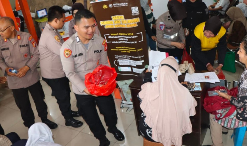 Aparat Polres Depok membagikan makanan ke masyarakat yang sedang mengurus SKCK. (Foto: Dok RUZKA INDONESIA) 