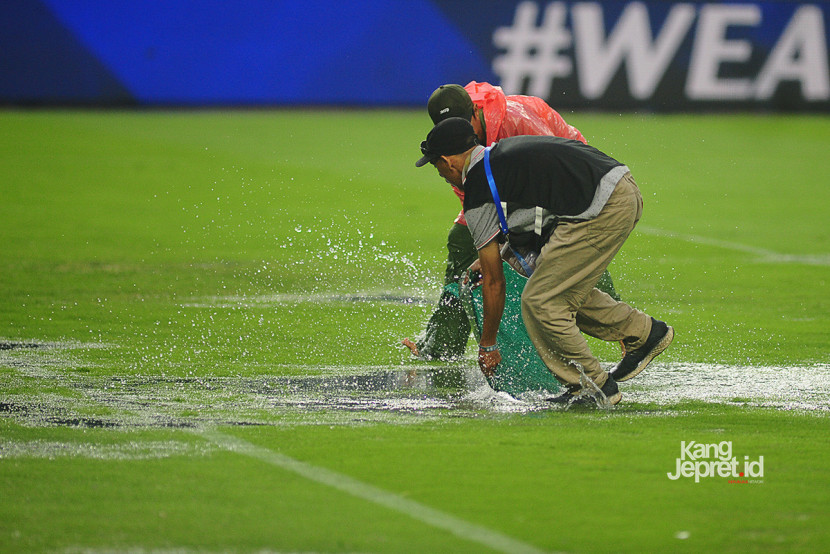 Petugas lapangan membuang air yang menggenangi lapangan stadion ketika laga Persib vs Persebaya dihentikan akibat hujan deras yang melanda Stadion Gelora Bandung Lautan Api, Bandung, Jumat (12/9/2025). (KANGJEPRET/ YOGI ARDHI) (Data: Nikon D700, Nikkor MF 300/2.8 ED)