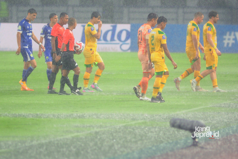 Wasit Candra dan tim kedua kesebelasan meninggalkan lapangan ketika laga Persib vs Persebaya dihentikan akibat hujan deras yang melanda Stadion Gelora Bandung Lautan Api, Bandung, Jumat (12/9/2025). (KANGJEPRET/ YOGI ARDHI) (Data: Nikon D700, Nikkor MF 300/2.8 ED)