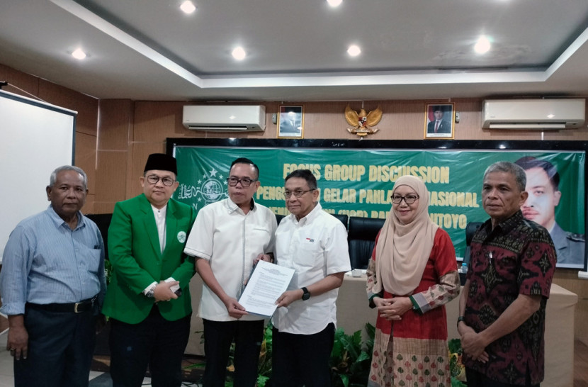 Kemas Khoirul Mukhlis (ketiga dari kiri) ketua panitia FGD menyerahkan rekomendasi hasil diskusi kepada Indra Bambang Utoyo (ketiga dari kanan). (FOTO: Maspril Aries) 