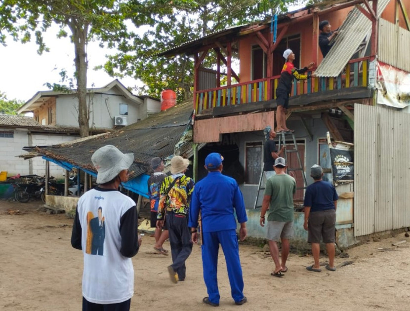Satpolairud Polres Garut bersama warga dan nelayan setempat bahu membahu memperbaiki rumah nelayan di Pantai Karang Papak. (Foto Dok. Ridwan)