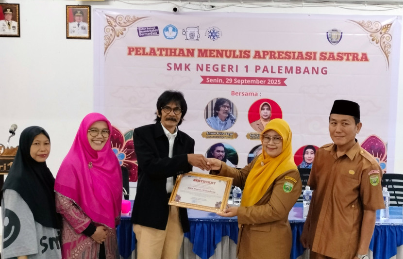 Ketua Koalisi Masyarakat Puisi Anwar Putra Bayu (ketiga dari kiri) menyerahkan sertifikat kepada Wakil Kepala SMKN 1 Palembang. (FOTO: Maspril Aries)