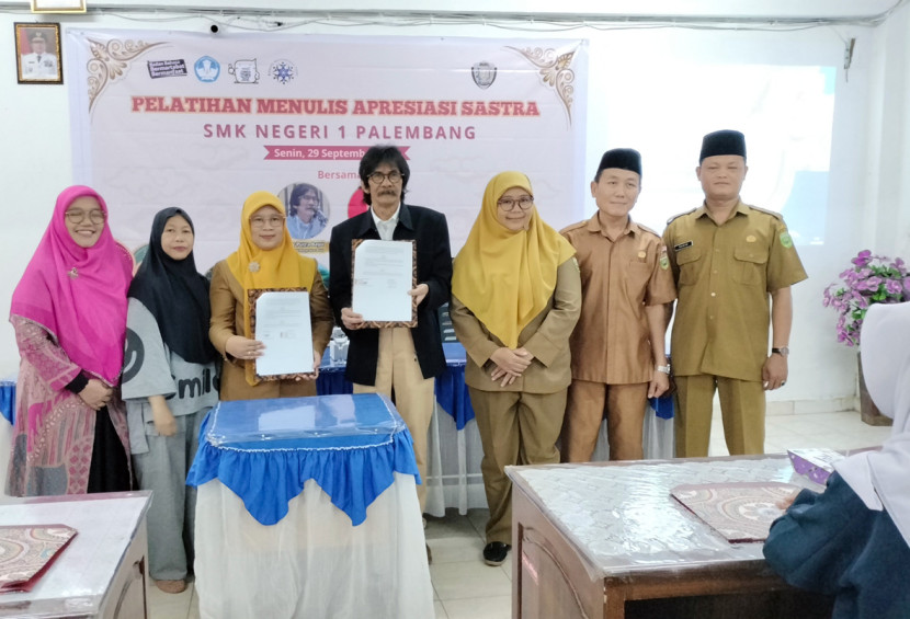 Ketua Koalisi Masyarakat Puisi Anwar Putra Bayu dan Wakil Kepala SMKN 1 memperlihatkan naskah kerjasama yang telah ditandatangani. (FOTO: Maspril Aries)