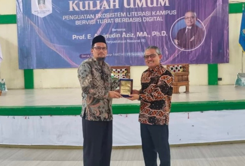 Wakil Rektor I IAI Persis Garut, Dr. Daris Tamin, M.Pd menyerahkan cendramata kepada Kepala Perpusnas RI, Prof. Aminudin Aziz. (Foto Dok. Taupiq)