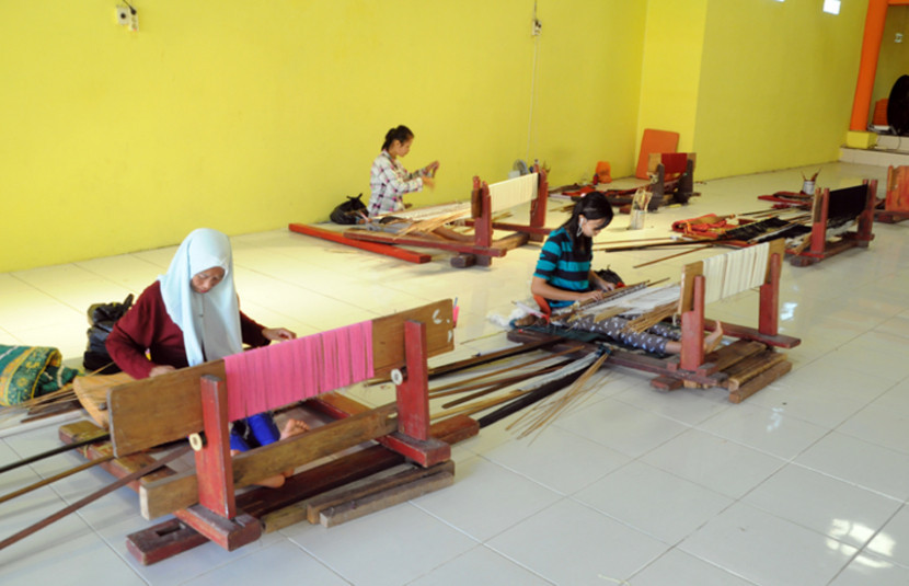Perempuan tengah menenun kain Songket Palembang. (FOTO: Maspril Aries)